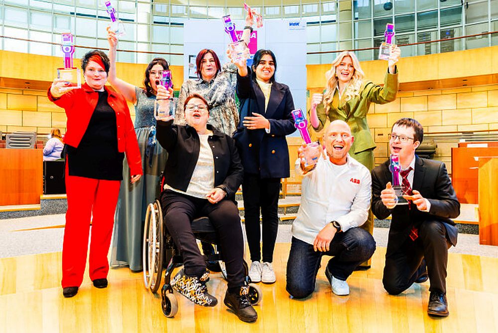 Gruppe von Männern und Frauen, die einen kleinen Pokal hochhalten