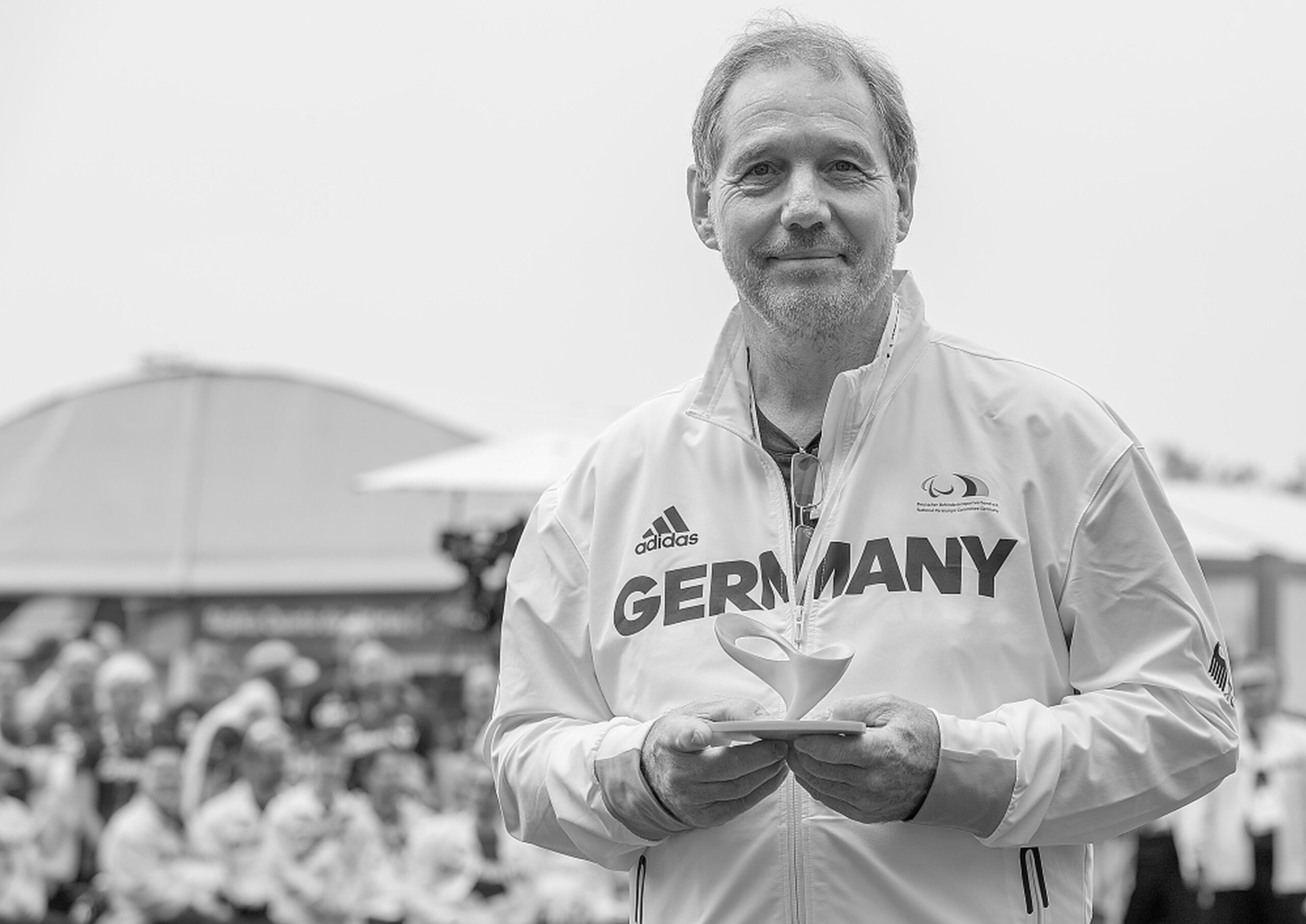 Bild eines Mannes mit weißer Trainingsjacke mit der Aufschrift Germany