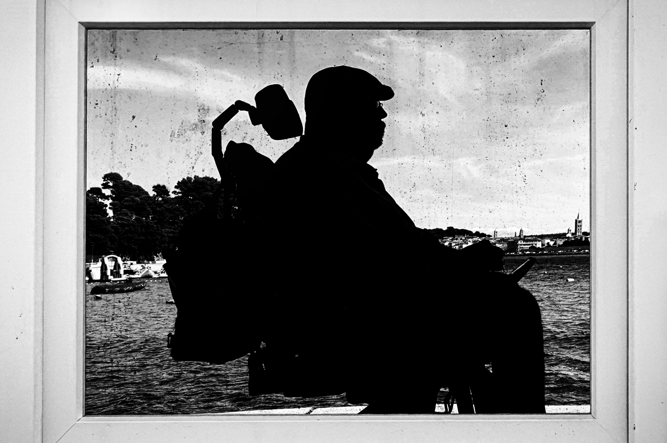 Silhouette von Ralph Milewski im Rollstuhl gespiegelt in einem Fenster - sw Foto